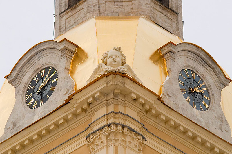 A clock and an image of a cherub at the Peter and Paul Cathedral in Saint-Petersburg, Russia