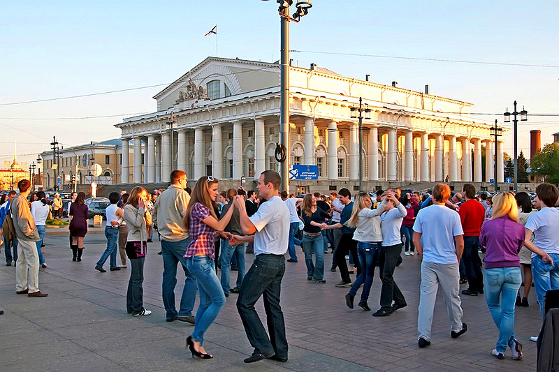 People dance on Birzhevaya Ploshchad (Stock Exchange Square) next to the Rostral Columns in Saint-Petersburg, Russia